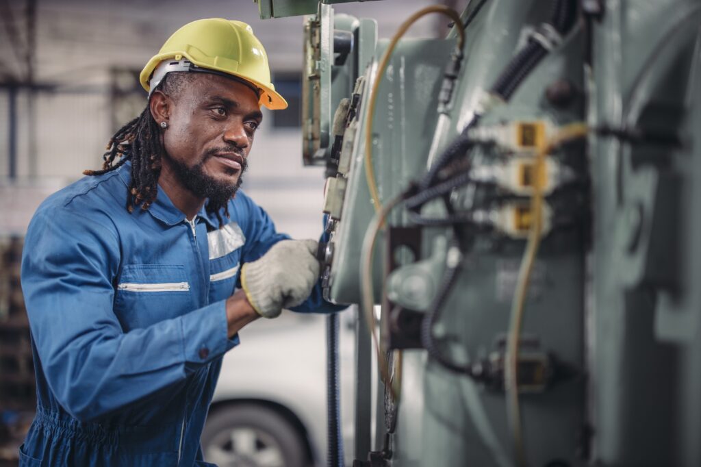 Technician adjusts and troubleshoots factory machinery for optimal performance and safety standard